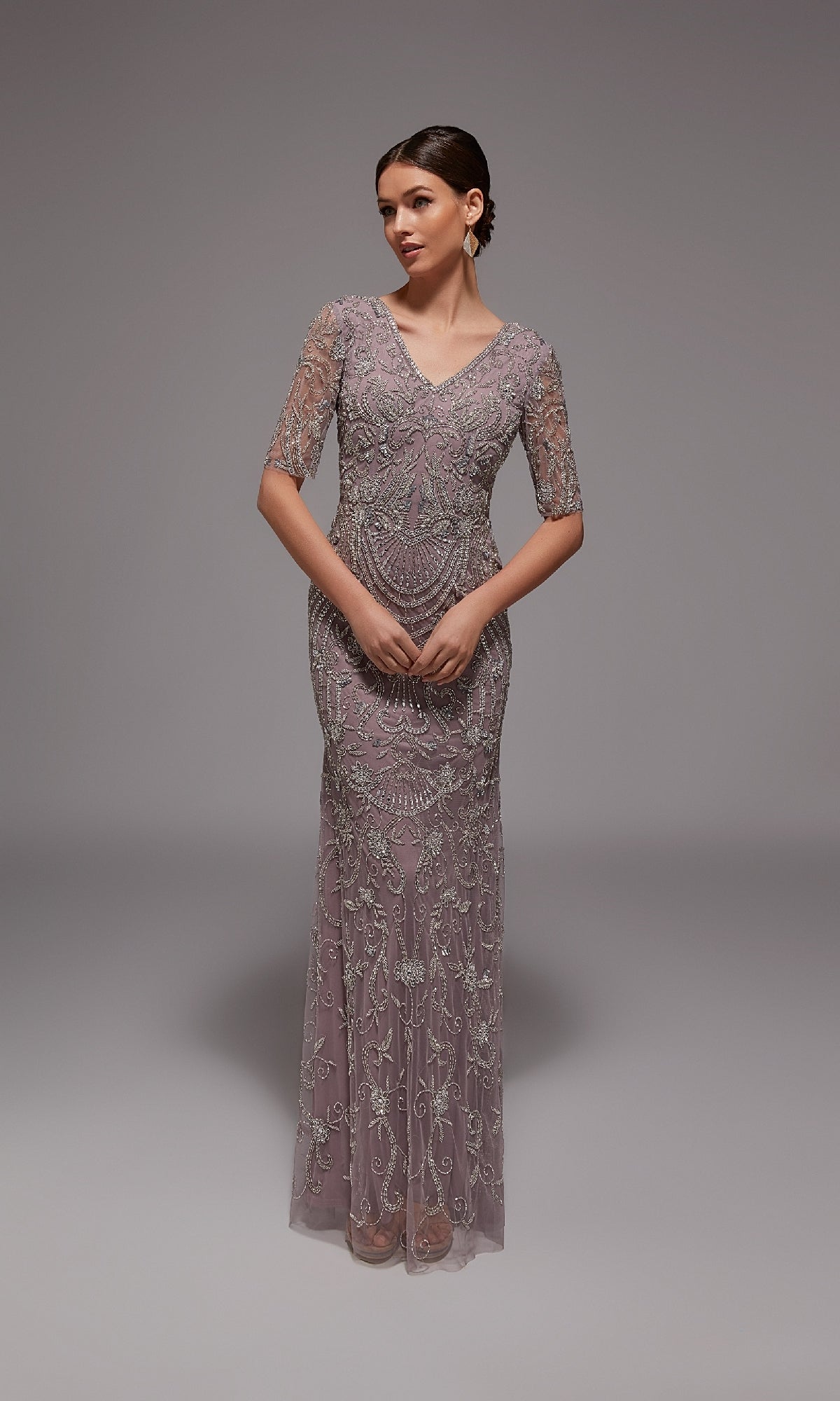 A woman models the Alyce 27824 long formal dress in mauve, featuring half sleeves, a V-neckline, and intricate beaded embroidery—an elegant choice for formal events—posed against a plain gray background.